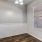 a room with a wood floor and a window with a light on the wall